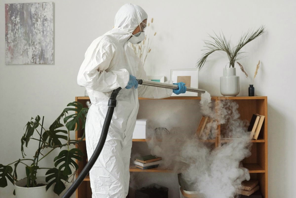 man in hazmat suit spraying for pests<br />
